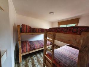 1 dormitorio con 2 literas en una habitación en Cabañas Olas del Bosque, en Pichilemu