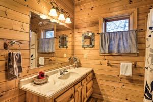 a bathroom with a sink and a mirror at Bryson City Cabin with Private Hot Tub and Game Room in Bryson City +27 photos
