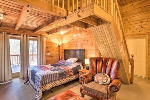 a bedroom with a bed and a chair in a cabin at Bryson City Cabin with Private Hot Tub and Game Room in Bryson City