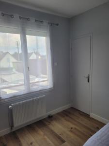 an empty room with a window and a door at Hotel de la Plage in Quinéville