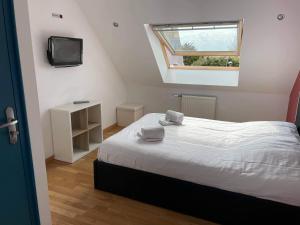 a bedroom with a bed with a tv and a window at Hotel de la Plage in Quinéville +89 photos