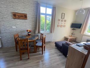 ein Wohnzimmer mit einem Tisch, Stühlen und einem Sofa in der Unterkunft Stará Morava Apartmán Zuzka, Tatranská Lomnica in Tatranská Lomnica