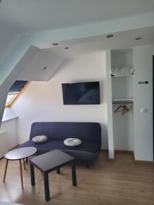 a living room with a blue couch and a table at Hotel de la Plage in Quinéville