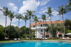 a resort with a swimming pool and palm trees at Trident Chennai in Chennai