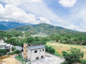 une vue aérienne sur une maison avec des montagnes en arrière-plan dans l'établissement Woolywo B&B, à Yuli