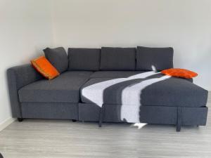 een grijze bank met oranje en witte kussens erop bij Domus Fersina in Trento