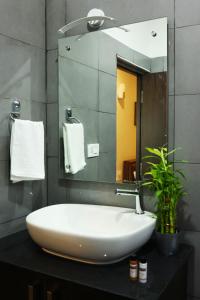 een badkamer met een witte wastafel en een spiegel bij HOTEL PARK KRISHNA in Tirupati