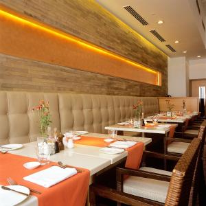 a dining room with tables and chairs and a brick wall at Trident Chennai in Chennai