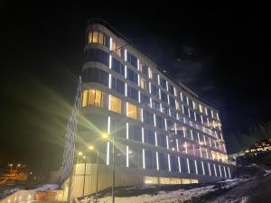 弦納的住宿－Czarna Góra Biała Perła EnergyApart，一座高大的建筑,晚上有灯