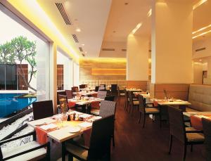 a restaurant with tables and chairs and a large window at Trident Chennai in Chennai