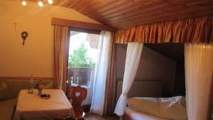 Zimmer mit einem Bett, einem Tisch und einem Fenster in der Unterkunft Schusterhof in Innsbruck