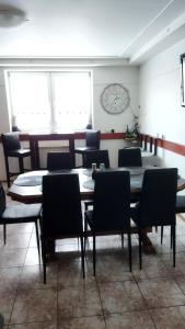 una sala da pranzo con tavolo, sedie e orologio di Lucky Cat a Nová Lesná