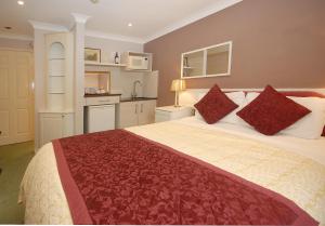 1 dormitorio con 1 cama grande con almohadas rojas en Marlborough House - Guest House en Oxford