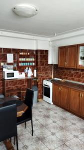 a kitchen with wooden cabinets and a table and a stove at Lucky Cat in Nová Lesná