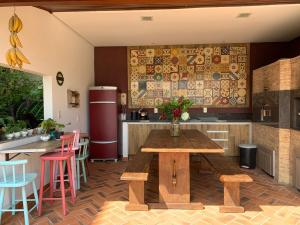 a kitchen with a wooden table and a refrigerator at House Flat Cacupé em Florianópolis in Florianópolis