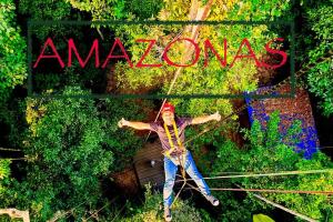 un hombre en una tirolesa frente a la señal amazónica en Bungalow In The Jungle -Ecolodge HUITOTO, en Leticia