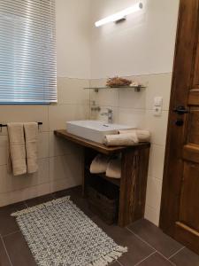 a bathroom with a white sink and a rug at Bonapart in Stumm