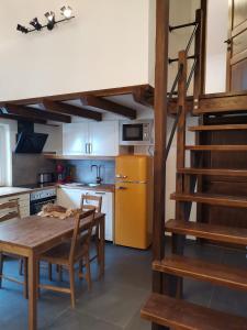 a kitchen with a wooden table and a spiral staircase at Bonapart in Stumm