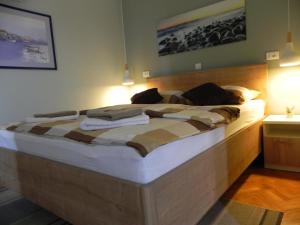 a large wooden bed in a room with lights at Apartments Katalenić in Selce