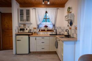 cocina con armarios blancos y nevera blanca en Stodola Harrachov en Harrachov
