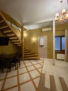 ein Esszimmer mit einer Treppe und einem Esstisch in der Unterkunft Двухуровневая квартира на Дерибасовской in Odessa