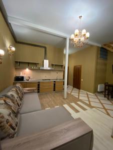 ein Wohnzimmer mit einer Couch und einem Kronleuchter in der Unterkunft Двухуровневая квартира на Дерибасовской in Odessa