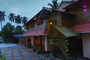 a building with a staircase leading up to it at CANALVIEW PRIVATE COTTAGE Azhikkal Ayiram Thengu in Panmana