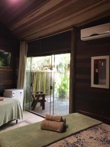 a bedroom with a bed and a sliding glass door at Vila da Pousadinha in Ilha do Mel