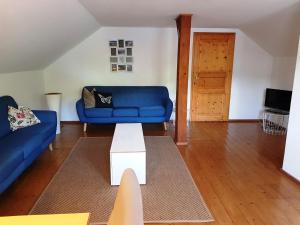 un soggiorno con un divano blu e un tavolo di Ferienwohnungen Zechmeister a Marktschellenberg