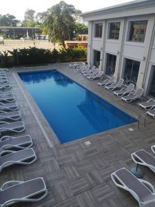 Una gran piscina con sillas y un edificio. en Place Lafayette Espectacular Vista Piso 19, 1 Dorm, Amenities, en Punta del Este