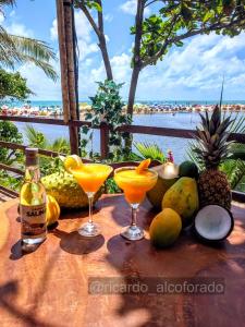 een tafel met twee cocktails en wat fruit erop. bij Praia Bela Paraíba Casa 220 in Pitimbu