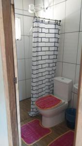 a bathroom with a toilet and a shower curtain at Pousada Margareth in Ilha do Mel