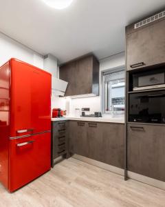 a red refrigerator in a kitchen with a window at Brand-New , Delux apt in Central Athens! in Athens