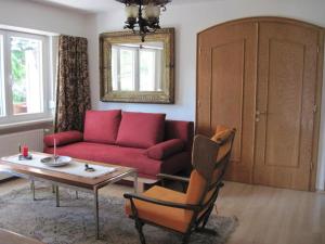 ゼーフェルト・イン・チロルにあるAntoni Apartementsのリビングルーム(赤いソファ、テーブル付)