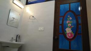 a bathroom with a bathroom door with a painting on the wall at Vibgyor Villa in Munnar