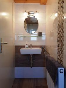 a bathroom with a sink and a mirror at Ferienwohnungen Zechmeister in Marktschellenberg