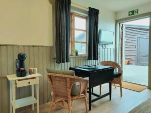 ein Esszimmer mit einem Tisch, Stühlen und einem Fenster in der Unterkunft Riverfront Lodge Hella in Hella