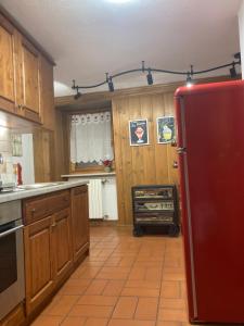 a kitchen with wooden cabinets and a red refrigerator at Maison Francey in Pré-Saint-Didier