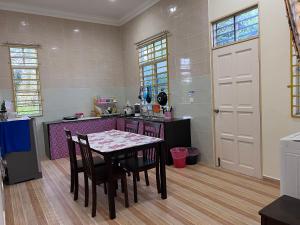 a kitchen with a table and chairs in a room at Teratak Anakanda in Kuala Berang +21 photos