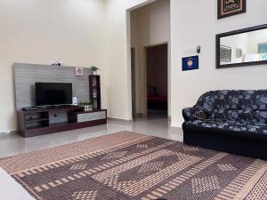 a living room with a couch and a television at Teratak Anakanda in Kuala Berang