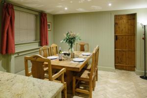 a dining room with a wooden table and chairs at Lavender Cottage in Thorndon