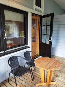 a wooden table and two chairs on a porch at Kuerkömmeli, Äkäslompolo in Äkäslompolo +2 photos