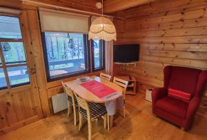 une salle à manger avec une table et une chaise rouge dans l'établissement Kuerkömmeli, Äkäslompolo, à Äkäslompolo
