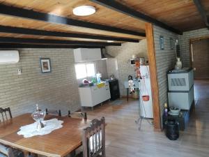 eine Küche und ein Esszimmer mit einem Tisch und einem Kühlschrank in der Unterkunft Casa en Jaureguiberry a 5 cuadras de la playa in Jaureguiberry