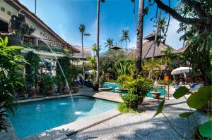 a pool at a resort with a fountain at Sativa Sanur Cottages in Sanur