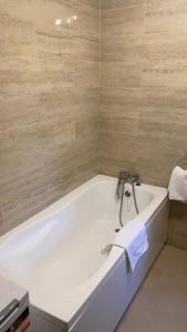 a white bath tub with a faucet in a bathroom at Grant Apartament in Arad