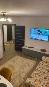 a living room with a flat screen tv on the wall at Grant Apartament in Arad