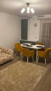 a living room with a table and chairs and a couch at Grant Apartament in Arad