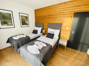 2 letti in una camera con parete in legno di Monte Amnis Apartment a Tatranska Strba