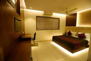 a bedroom with a bed and a television in it at Hotel Hindustan Residency Thane in Thane